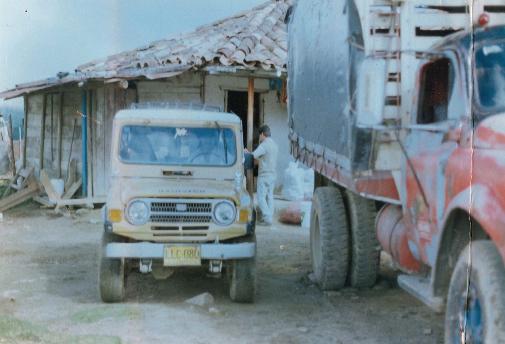 Dos camiones escaleras, o chiveros, estacionados frente a una casa rural